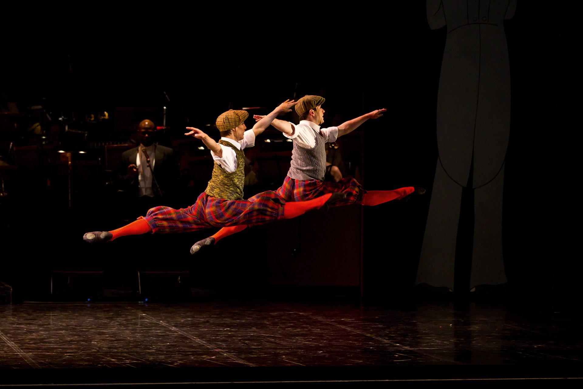 Dressed in flat caps and knickerbockers, Kevin Poeung and Benjamin Mitchell leap away from the camera