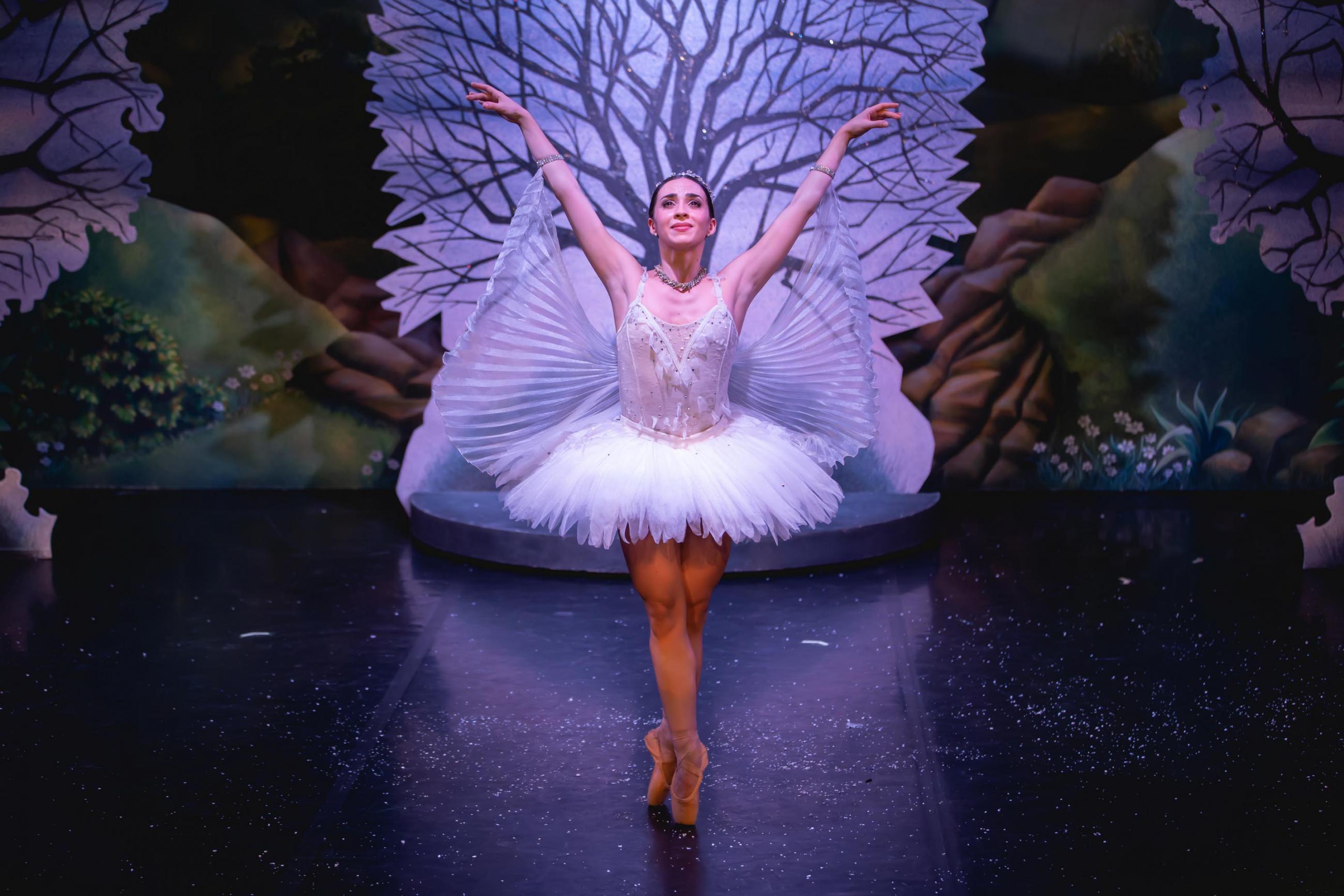 A dancer standing on pointe in the centre of the photo