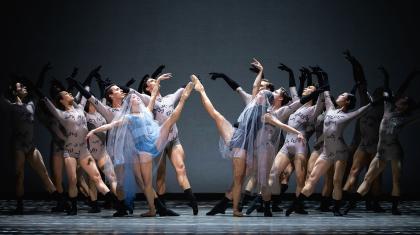 In white veils as they marry, held by Anne Litter's words represented by many dancers behind them